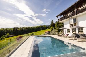 a swimming pool in front of a house at Haus Vogl Anger - Ferienwohnungen mit privater Sauna und beheizten Salzwasser Pool in Panoramalage und Nähe zu Salzburg und Berchtesgaden in Anger