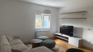a living room with a couch and a table at North & South Escape Kolašin in Kolašin