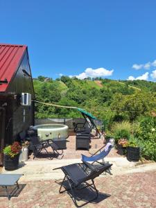 a patio with chairs and a table and a swing at Hiža Bake Veronike in Hrašćina