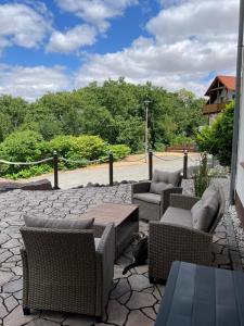 a patio with wicker chairs and tables on a stone patio at Ferienwohnung Liliana in Dannenfels