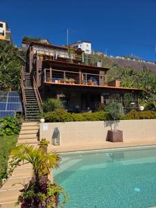 a house on top of a hill with a swimming pool at Les Terrasses Suites in Calheta