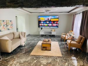 a living room with a couch and a flat screen tv at Kumnandi Modern Suite in Beacon Bay