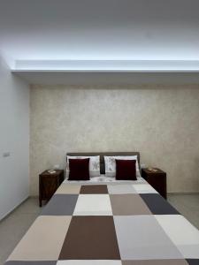 a bedroom with a large bed with a checkered floor at Casa Vittoria - Moderno bilocale a pochi passi dal mare in Galatone