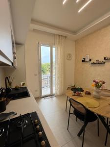 a kitchen and dining room with a table and a stove at Casa Vittoria - Moderno bilocale a pochi passi dal mare in Galatone