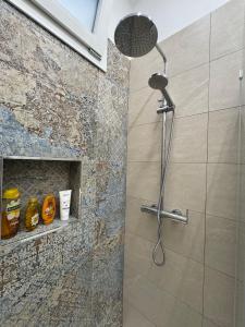 a shower with a shower head in a bathroom at Casa Vittoria - Moderno bilocale a pochi passi dal mare in Galatone