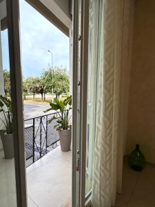 a door to a balcony with a view of a street at Casa Vittoria - Moderno bilocale a pochi passi dal mare in Galatone