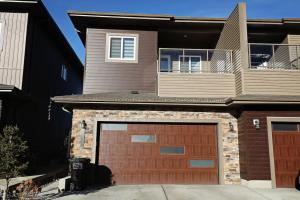 a house with a brown garage door in front of it at Three King Beds Central AC Fireplace Park Disney in Edmonton