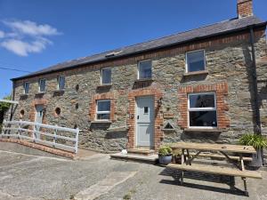 a stone cottage with a picnic bench in front of it at The Barn at Bar Hall Bay in Portaferry