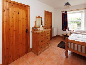 a bedroom with a bed and a mirror and a dresser at The Barn at Bar Hall Bay in Portaferry
