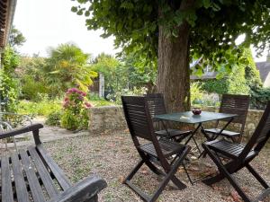 a table and two chairs sitting next to a tree at Maisons d'antan Giverny in Giverny +8 photos