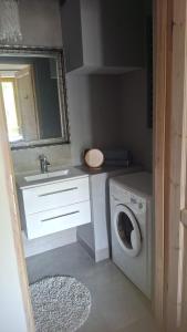 a bathroom with a sink and a washing machine at Apartament na Wzgórzu in Wieliczka