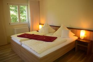 Schlafzimmer mit einem Bett mit weißer Bettwäsche und Kissen in der Unterkunft Tagungshaus Regina Pacis in Leutkirch im Allgäu
