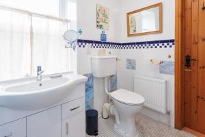 a white bathroom with a sink and a toilet at The Barn at Bar Hall Bay in Portaferry