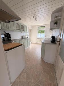 a kitchen with white cabinets and a tile floor at StadtQuartier Gardelegen in Gardelegen +11 photos
