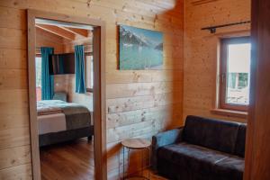 a room with a bed and a couch in a cabin at Schickster Sky Lodge und Chalet Rossi in Leutasch