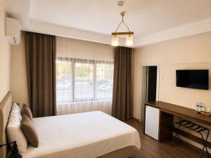 a hotel room with a bed and a television at La Pearl Konaklama in Istanbul