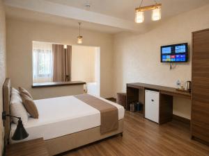 a bedroom with a bed and a desk and a television at La Pearl Konaklama in Istanbul