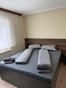 a bed in a room with three pillows on it at Руми in Velingrad
