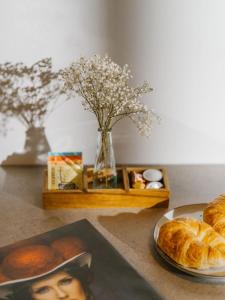 a table with a plate of pastries and a vase of flowers at Boutique Apartments Freiburg - Elsa in Freiburg im Breisgau