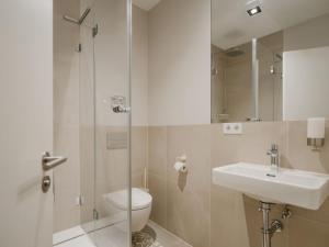 a bathroom with a toilet and a sink and a shower at Boutique Apartments Freiburg - Elsa in Freiburg im Breisgau