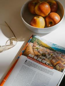 a book sitting on a table with a bowl of fruit at Boutique Apartments Freiburg - Elsa in Freiburg im Breisgau