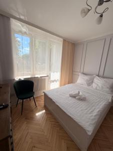 a bedroom with a bed and a chair and a window at Apartament centrum in Białystok