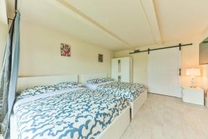 two beds in a white room with blue and white sheets at Island Paradise Villa RNT-01125 in Cape Coral