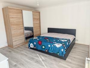 a bedroom with a bed and a large mirror at Shriji Homes in Watford West Station