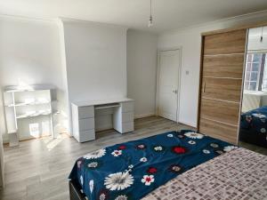 a bedroom with a bed and a desk in it at Shriji Homes in Watford West Station