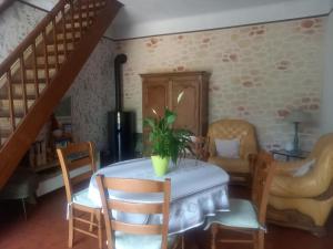 a dining room with a table with a plant on it at Clos Le Canoel in Elbeuf