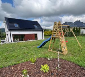 a playground with a slide in a yard with a house at Dom z widokiem in Miszkowice