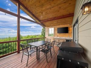 a deck with a table and chairs and a television at Viewtopia in Beech Mountain