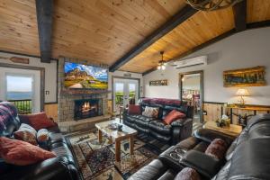 a living room with leather couches and a fireplace at Viewtopia in Beech Mountain