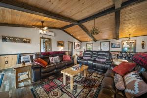 a living room with leather furniture and wooden ceilings at Viewtopia in Beech Mountain +26 photos