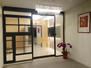 a room with a door and a vase with a plant at Boston Plus Hotel in Chiayi City