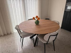a wooden table with chairs and a vase with flowers on it at The Corner-GILBERT in Oedelem +18 photos