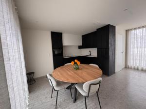 a dining room with a wooden table and chairs at The Corner-GILBERT in Oedelem