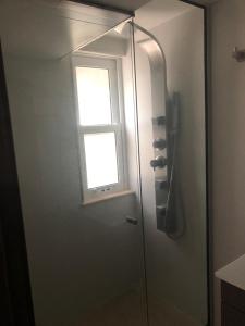 a glass shower with a window in a bathroom at Tiny House Mercedes in Mercedes +13 photos