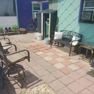 a patio with two chairs and a bench next to a building at ARMANI MANOR Rustic UNIT 2 in Wildwood