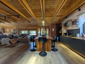 a kitchen and living room with a wooden ceiling at Kierunek Puszcza 2 Apartamenty - Balia, Sauna, Grota solna - max 14 osob in Narewka