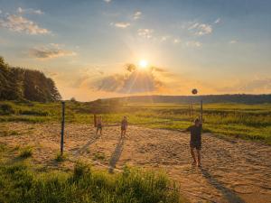 a group of three men playing a game of volleyball at Domki nad rzeką Narew in Ploski