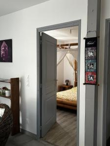 an open door to a bedroom with a bed at Entre Lac et Océan in Hourtin