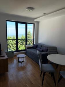 a living room with a couch and a table at Treska Kop Luccas Residence in Cajetina