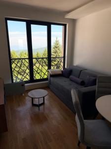 a living room with a couch and a table at Treska Kop Luccas Residence in Cajetina
