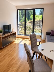 a living room with a couch and a table at Treska Kop Luccas Residence in Cajetina