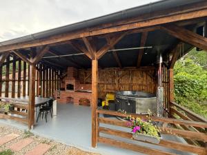 a large wooden pavilion with a table and a grill at Cabanutele "La Garaj" in Ocna-Mureşului +42 photos