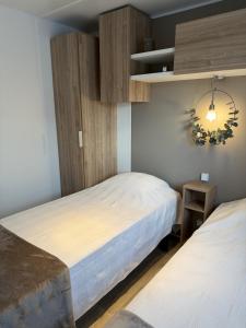 two beds in a room with wooden cabinets at Tiny House in Jukkasjärvi in Jukkasjärvi