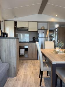 a kitchen and dining room with a wooden table and chairs at Tiny House in Jukkasjärvi in Jukkasjärvi +12 photos