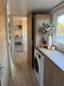 a laundry room with a washing machine and a vase of flowers at Tiny House in Jukkasjärvi in Jukkasjärvi