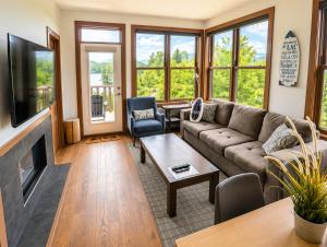 a living room with a couch and a tv at Appartement-Condo sur Lac Superieur-Mont-Tremblant in Lac-Superieur